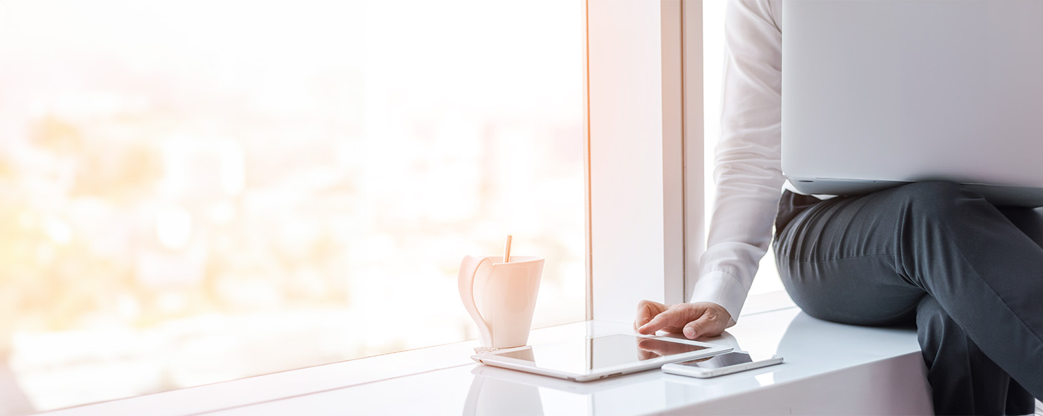 Een hand is bezig met het melden van een schadegeval in MyDVV, terwijl de telefoon binnen handbereik ligt om indien nodig meteen de DVV-consulent te bellen.