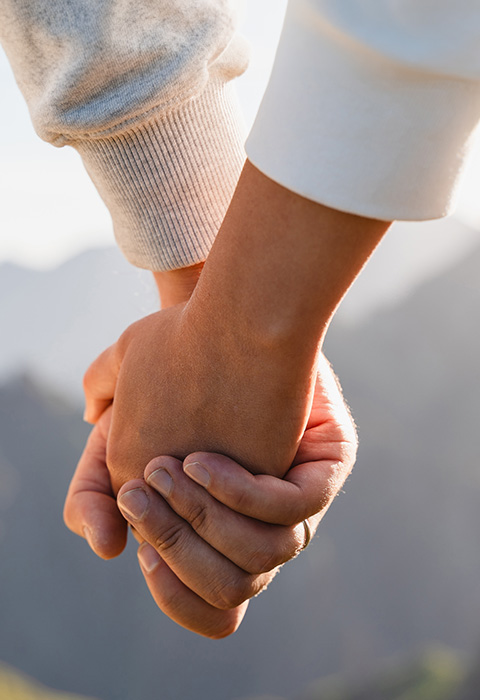 Deux mains jointes d'un couple pour illustrer la page de l'assurance décès et l'assurance obsèques de DVV