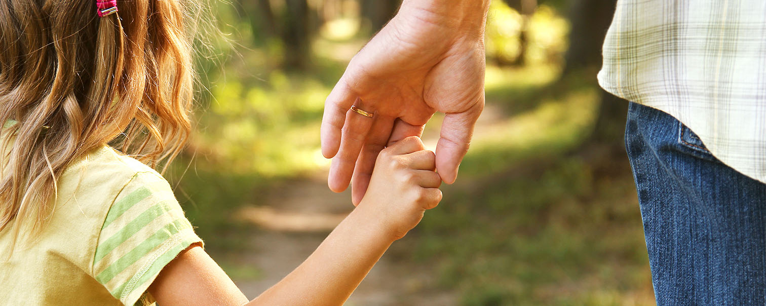 La main d'un enfant dans celle d'un parent pour illustrer la page de l'assurance obsèques de DVV