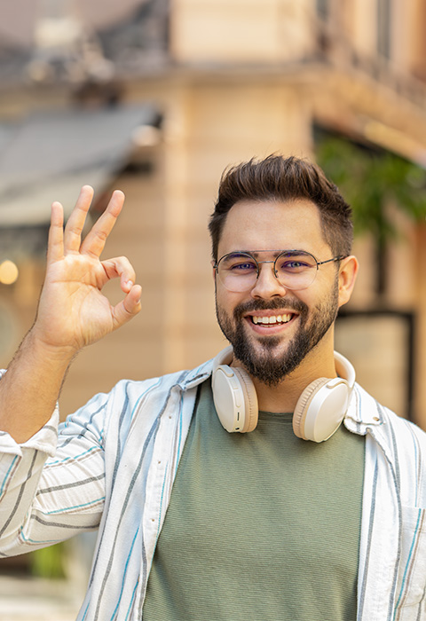 Een man die een ok-teken maakt in gebarentaal om de pagina van DVV over toegankelijkheid te illustreren. 