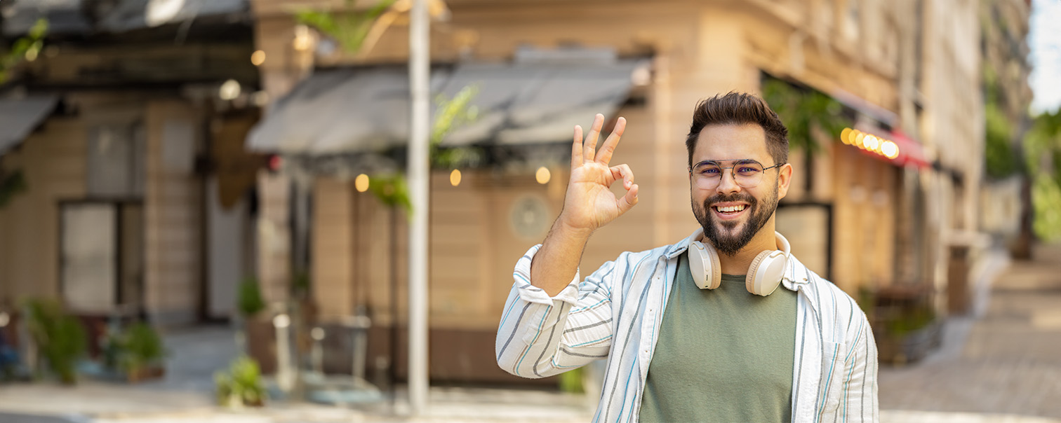 Een man die een ok-teken maakt in gebarentaal om de pagina van DVV over toegankelijkheid te illustreren. 