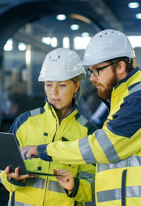 Deux personnes habillés en combinaison de chantier pour illustrer la page des assurances liées au batiments et matériel 