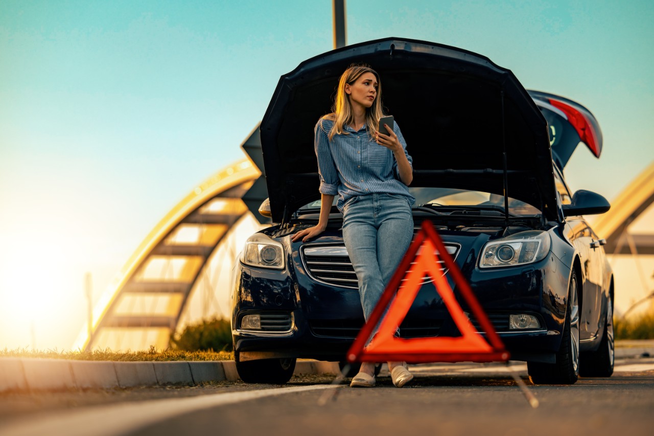 Car breakdown on road.Woman driver using mobile phone during problem car. Vehicle Insurance, maintenance and service concept.